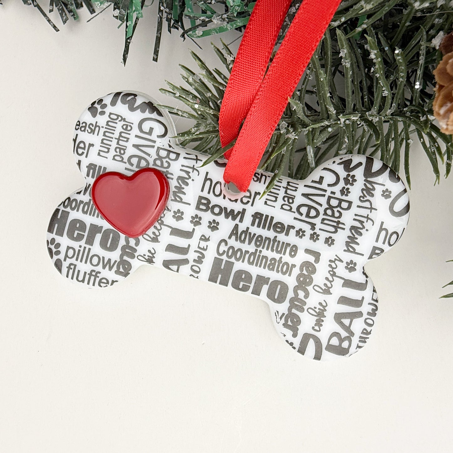 Handmade fused glass dog bone ornament with dog-themed word art and a glossy red heart, Christmas décor for dog lovers.