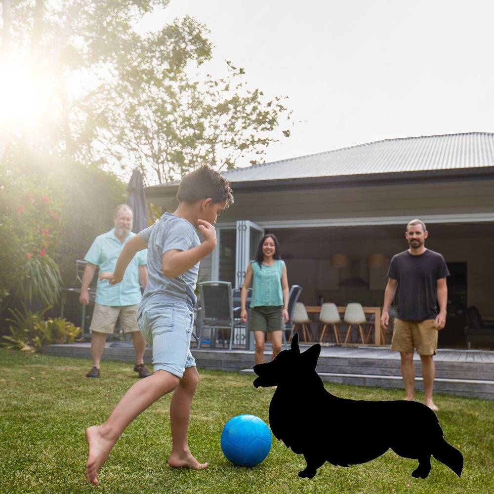 Precut glass shape of a corgi dog in a yard.