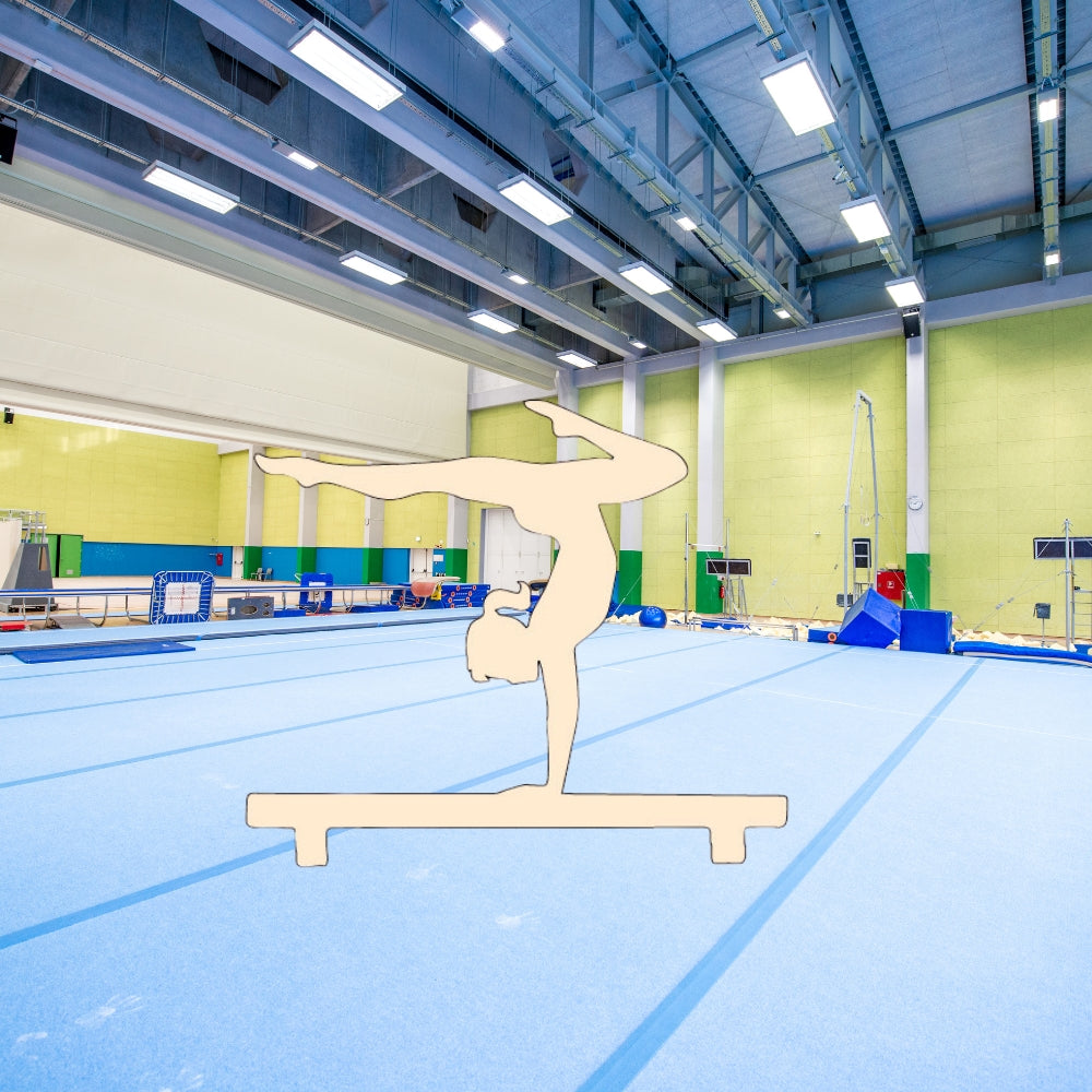Precut glass shape of a gymnast on balance beam in a gym.