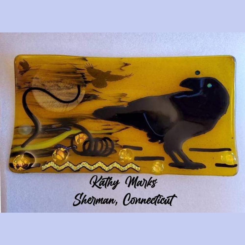 Precut glass shape of a raven in an art piece.