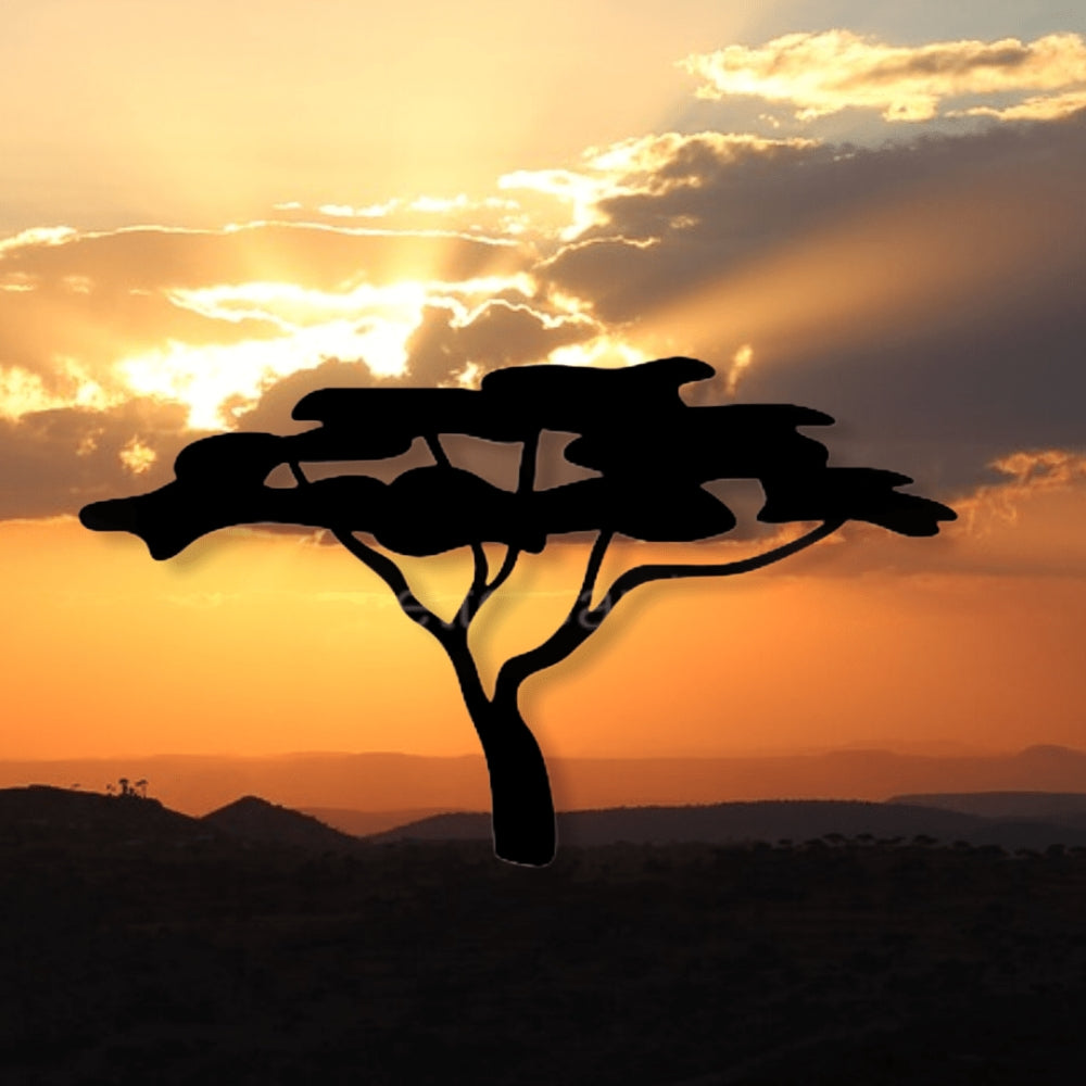 Precut glass shape of a tree with a sunset landscape.
