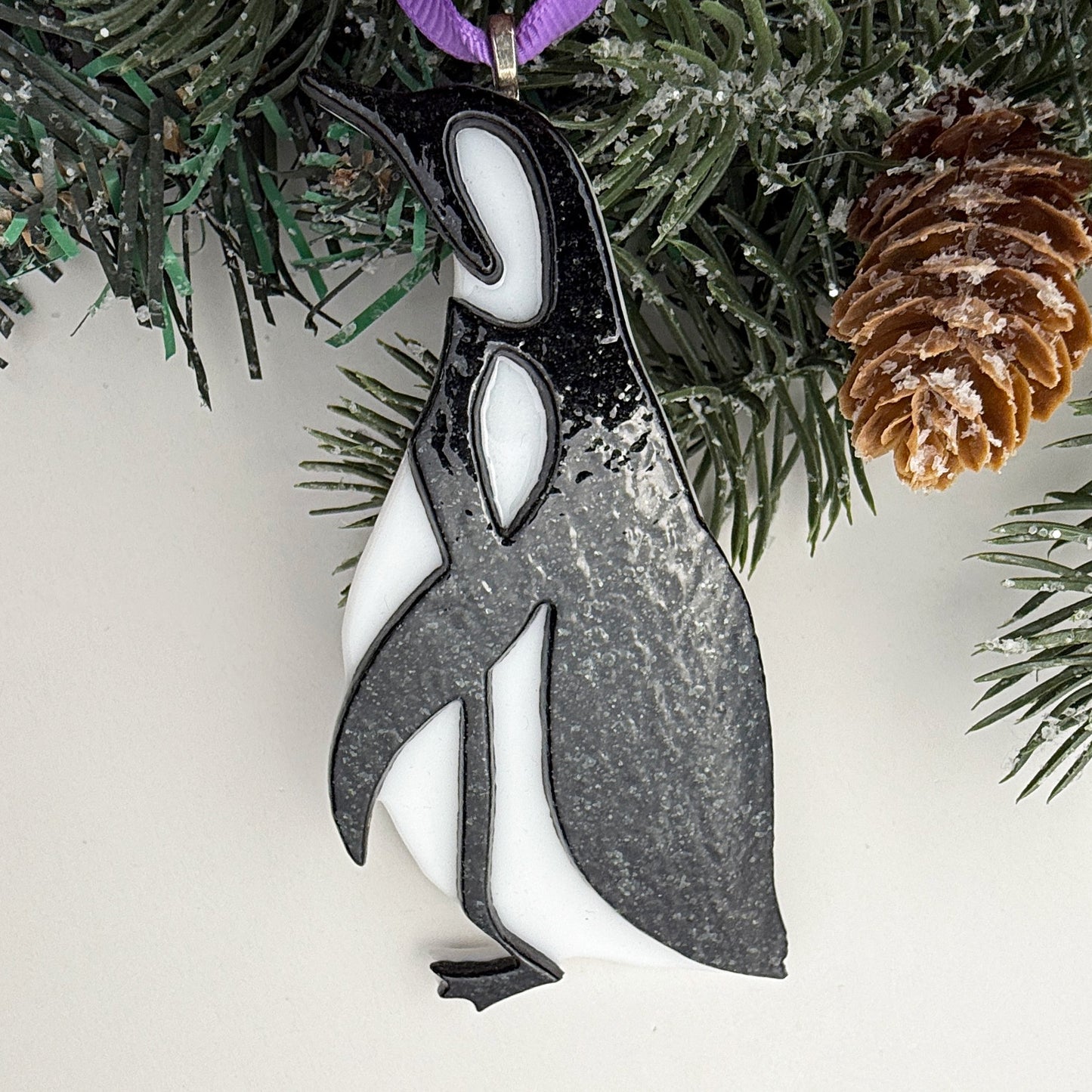 Elegant black and white fused glass penguin ornament with a smooth glossy finish, minimalist Christmas décor.