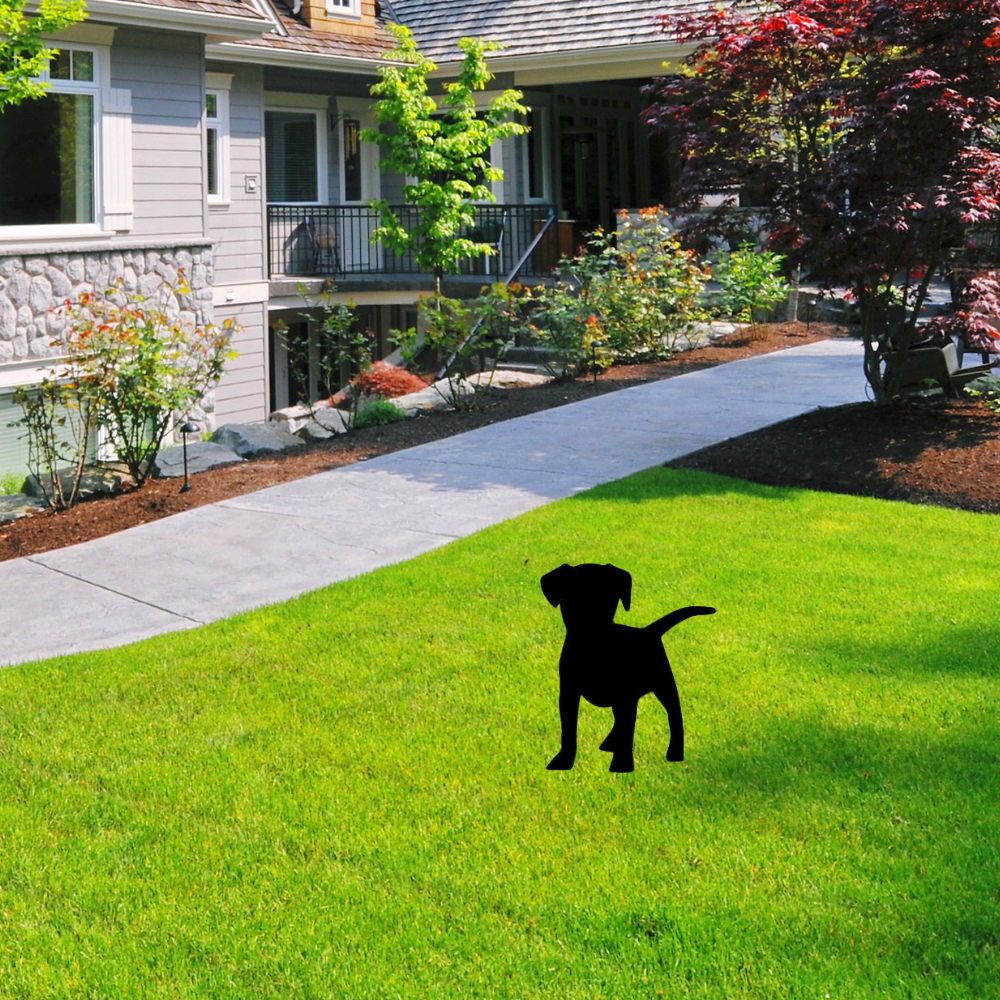 Precut glass shape of a puppy dog in a yard.