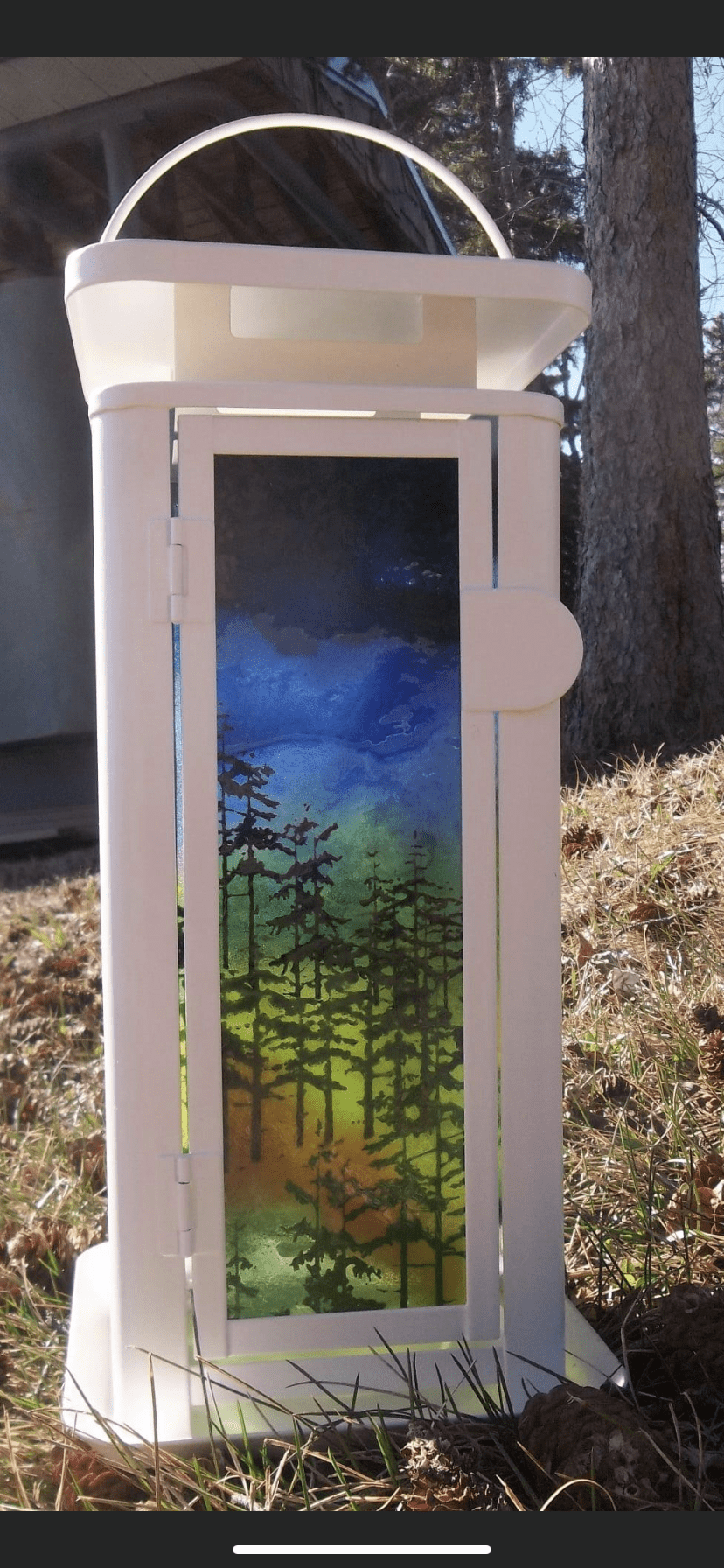 Fused glass lantern panel featuring a forest silhouette printed on glass with layered blue, green, and amber tones