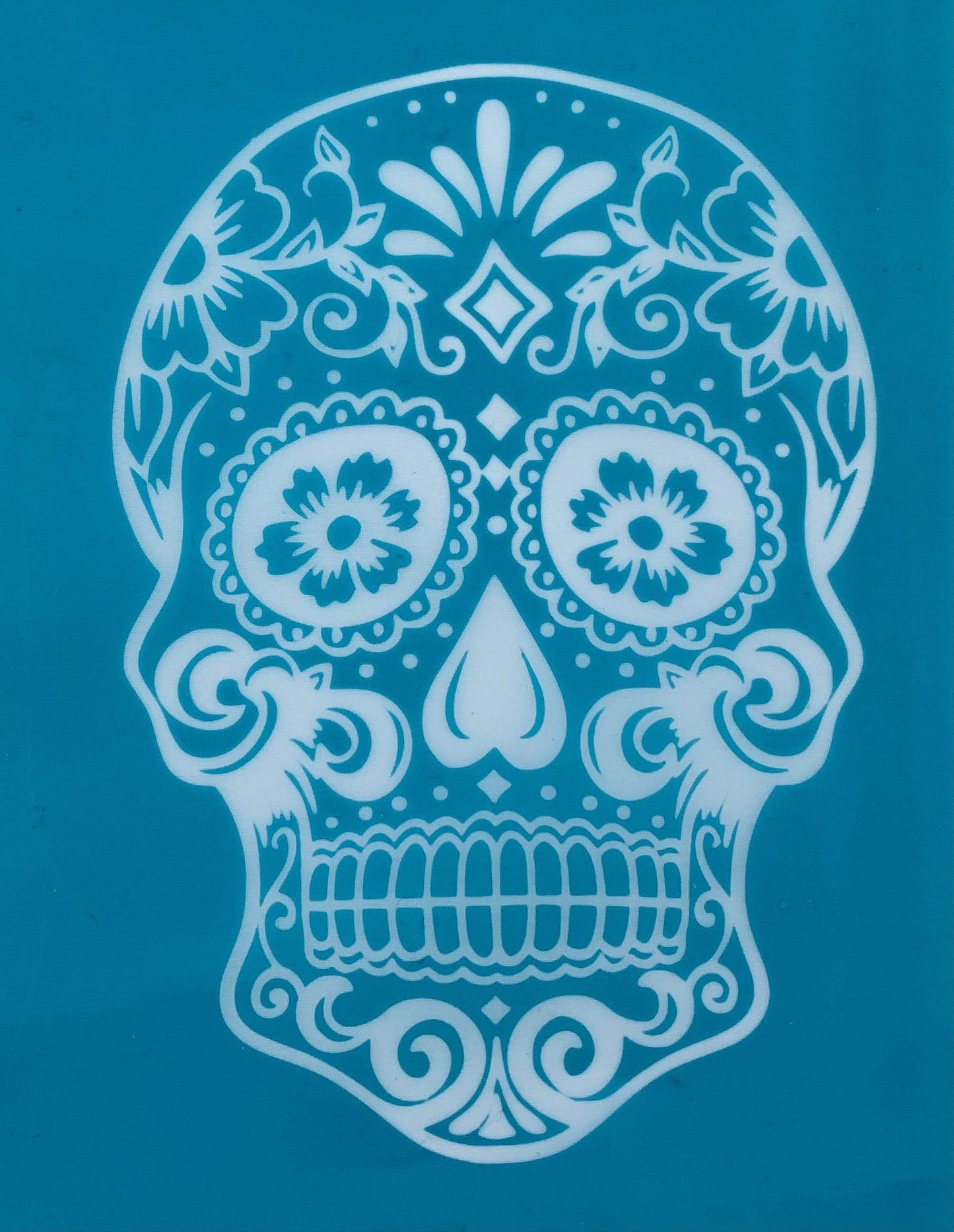 Day of the Dead sugar skull silk screen stencil featuring detailed floral motifs, shown exposed on blue screen mesh