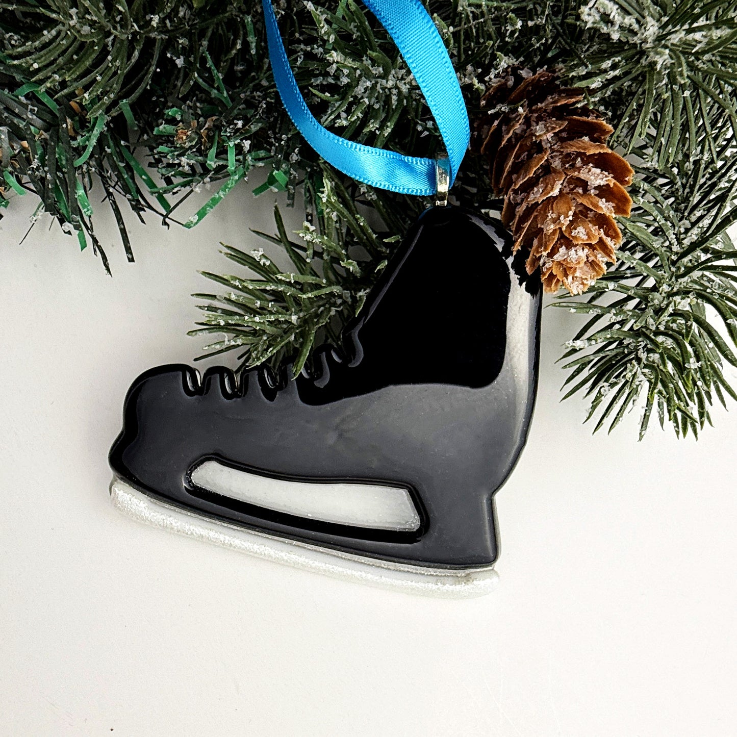 Handmade black fused glass hockey skate ornament with a sparkling white blade, winter sports Christmas décor.