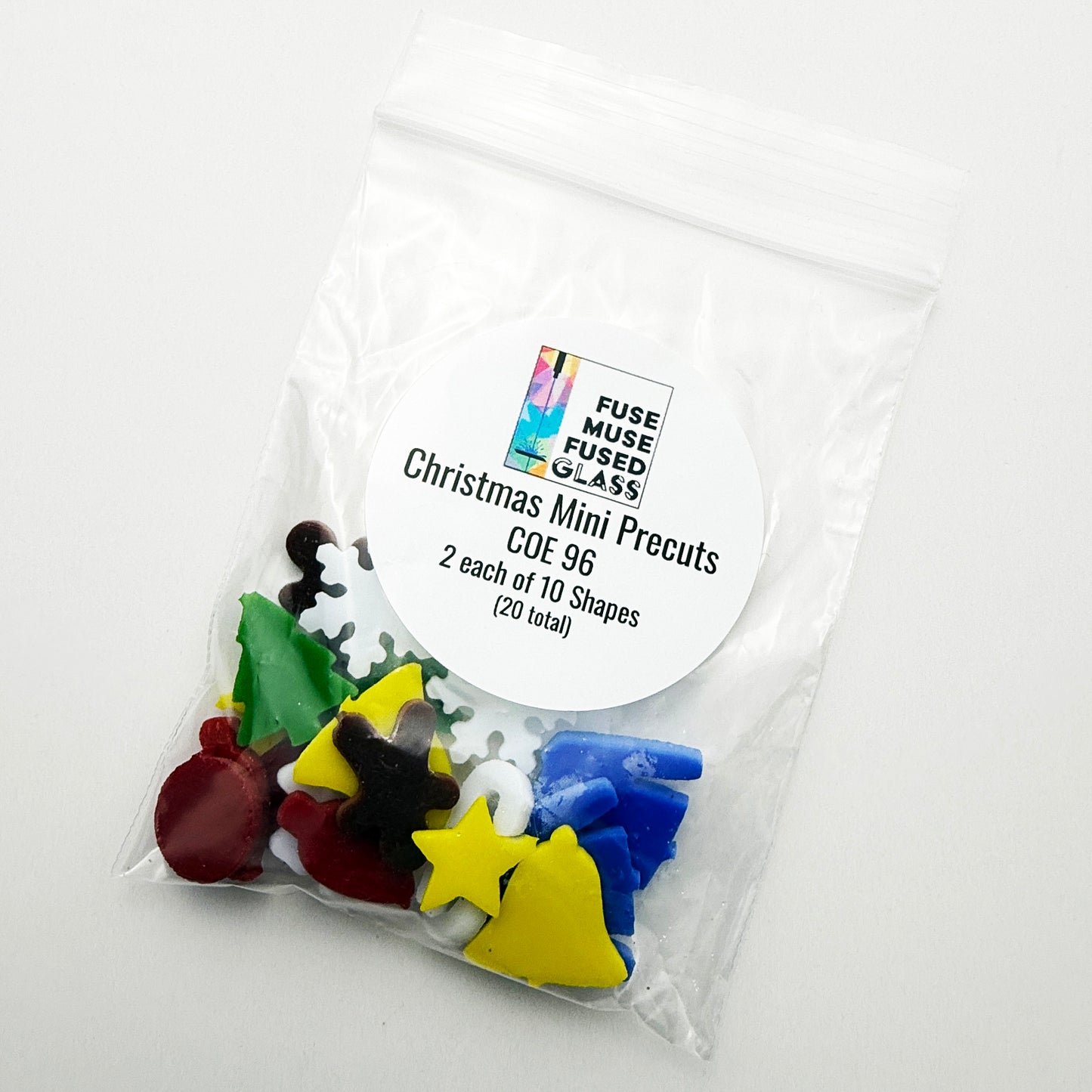 Bag of COE 96 Christmas mini precut glass shapes from Fuse Muse Fused Glass, showing 20 tiny embellishments for fused glass ornaments and holiday projects.