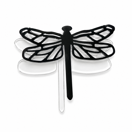 Black dragonfly outline layered over a clear precut glass dragonfly for a fused glass art project.