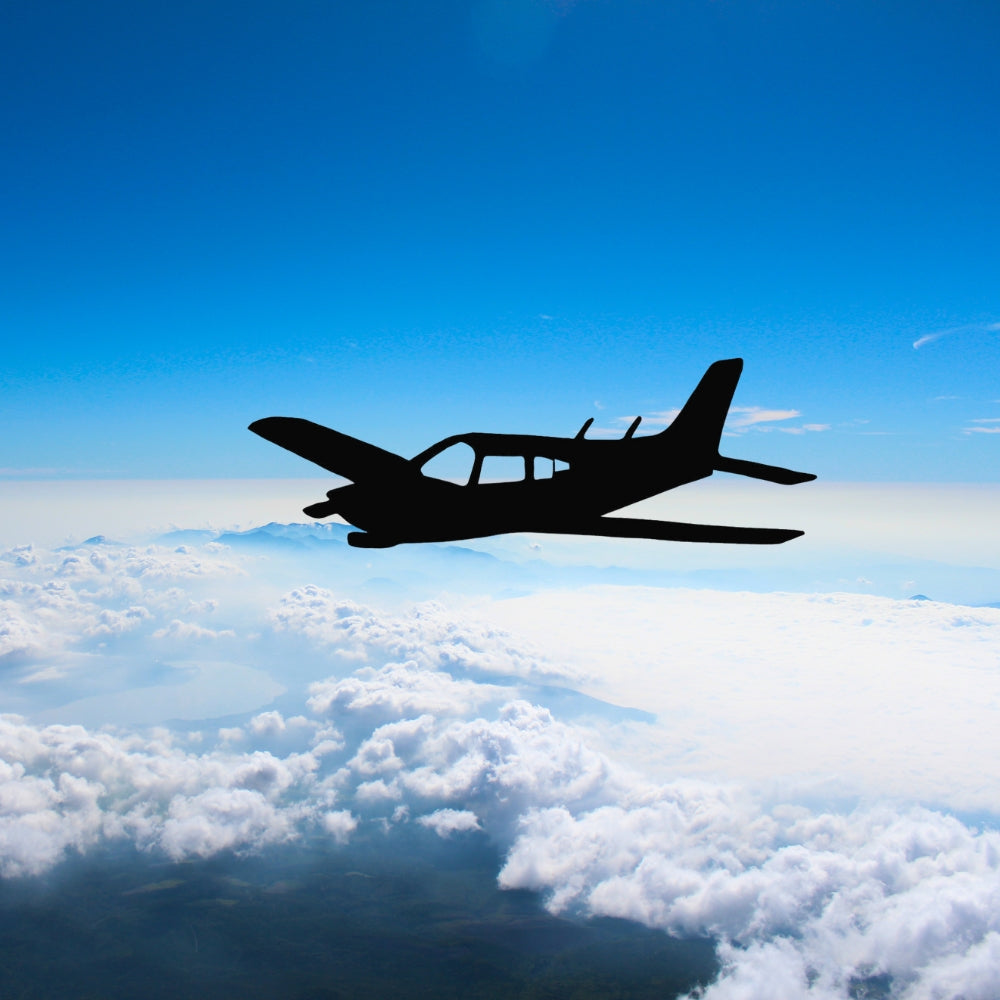 Precut glass shape of an airplane above the clouds.