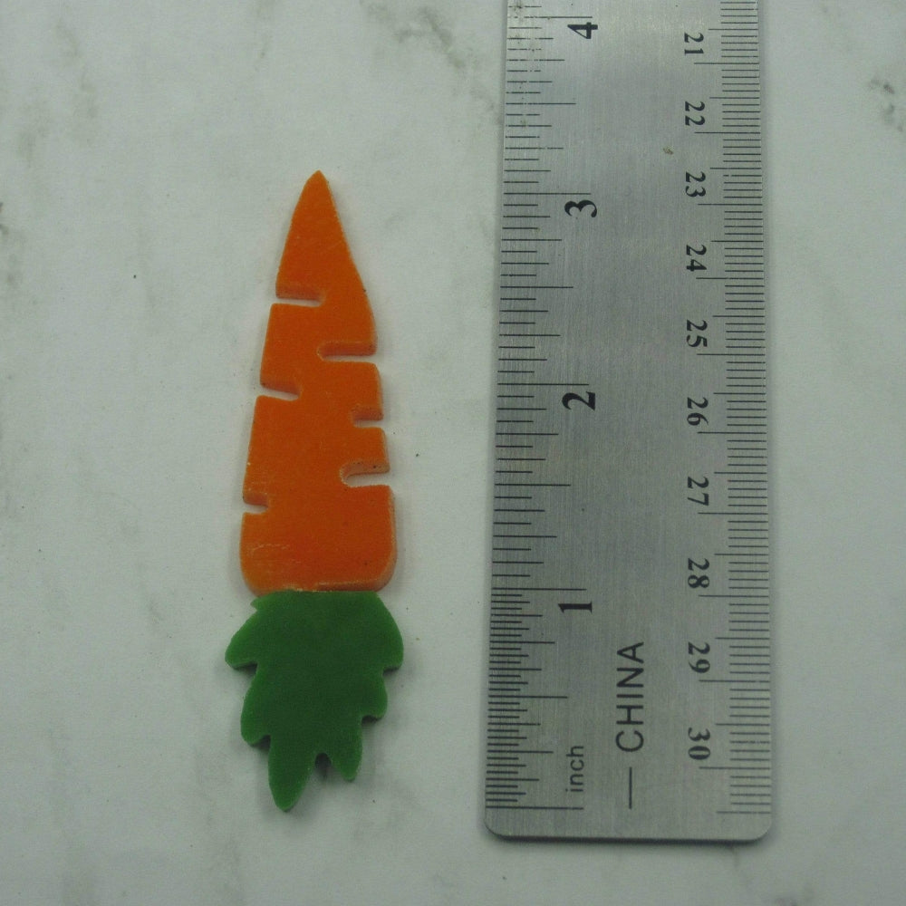 Precut glass shape of a carrot next to a ruler.