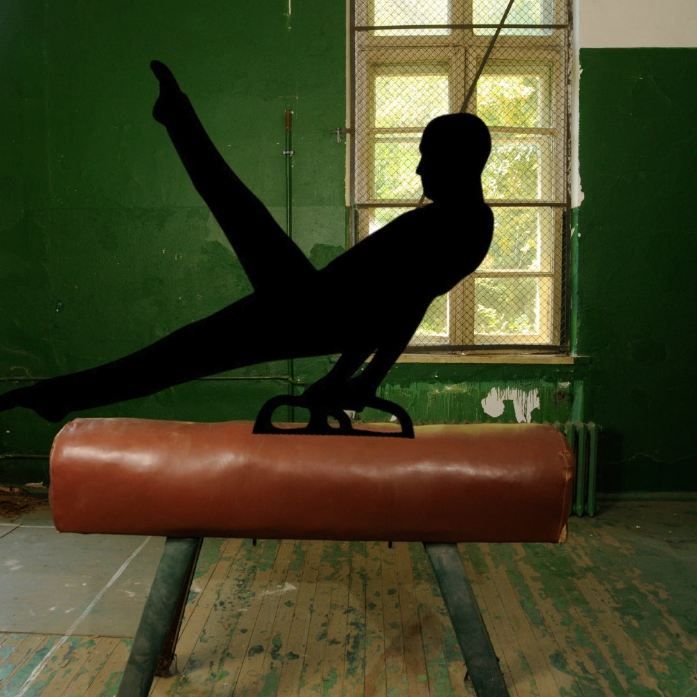 Precut glass shape of a gymnast on a pommel horse in a gym.