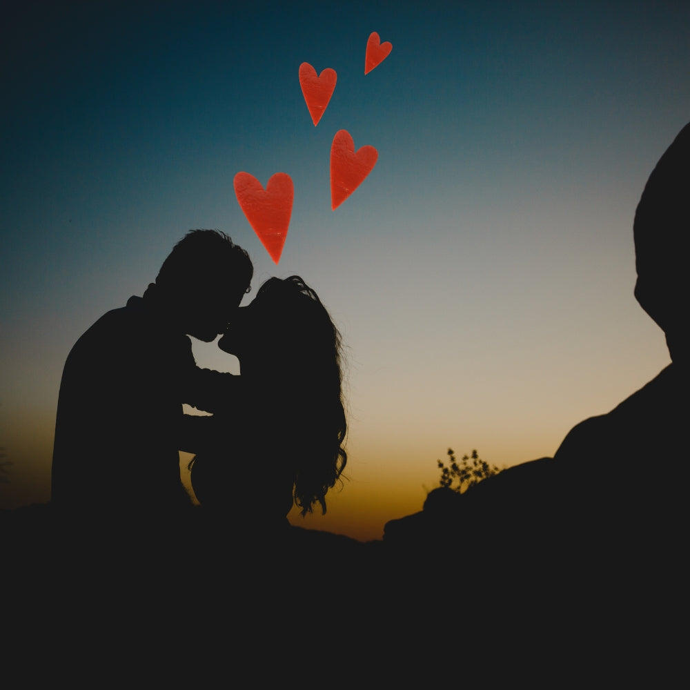 Precut glass shape of hearts with a silhouette couple kissing.