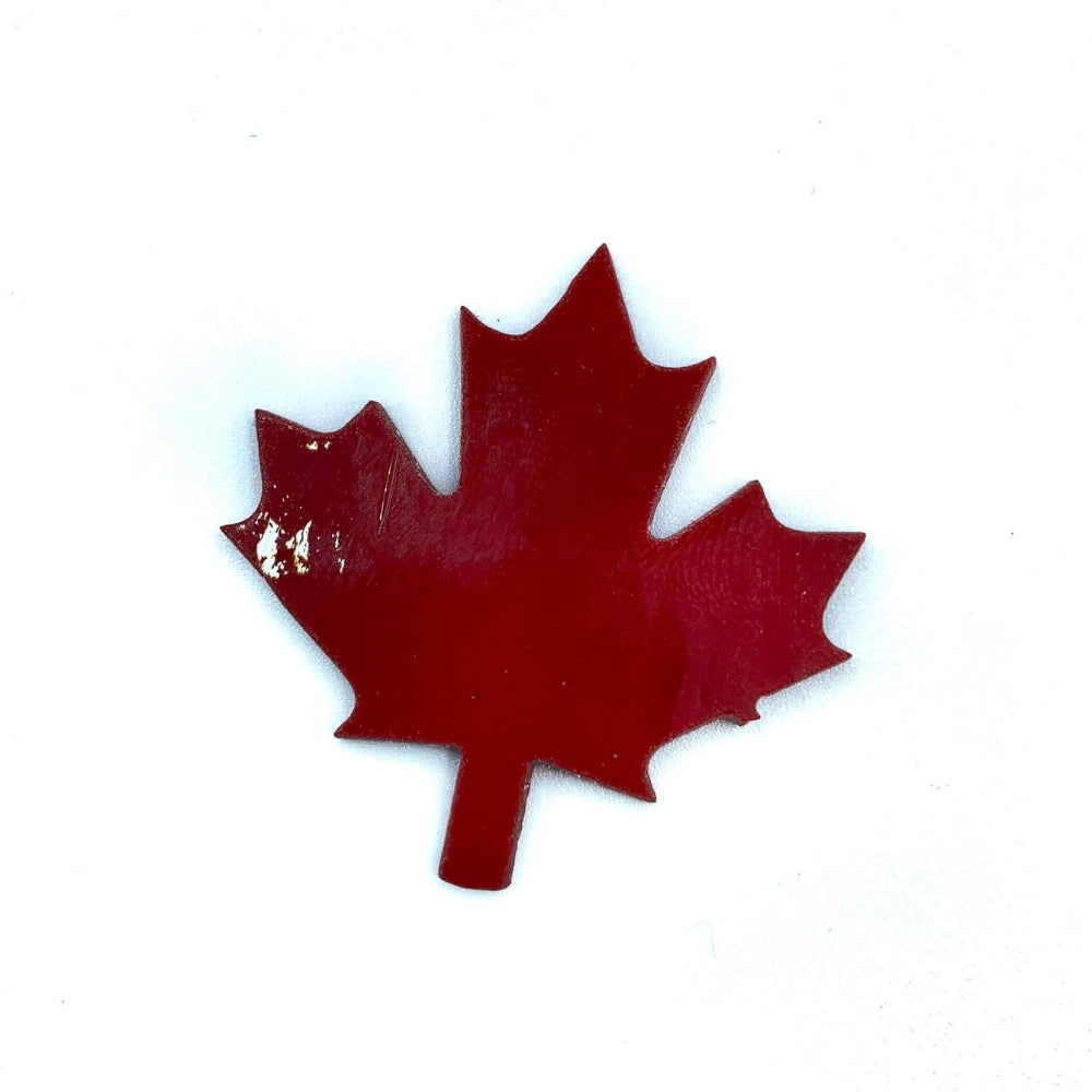 Precut glass shape of a maple leaf in red glass.