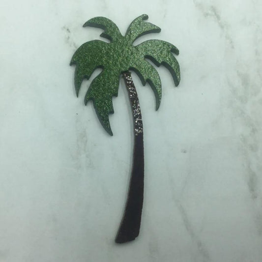 Precut glass shape of a palm tree in green and brown.
