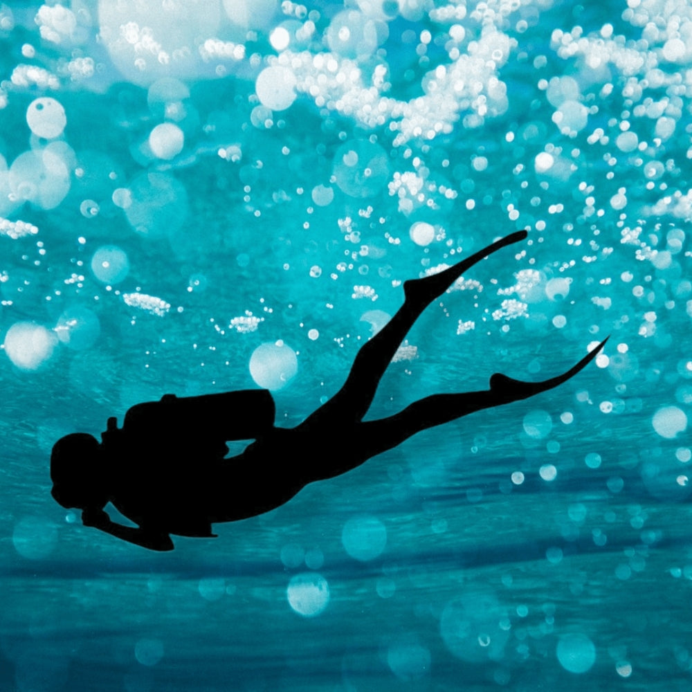 Precut glass shape of a scuba diver in the ocean.