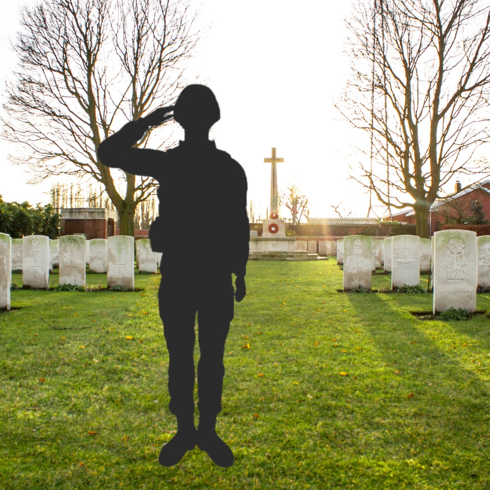 Precut glass shape of a soldier beside gravestones.