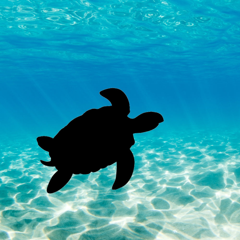 Precut glass shape of a turtle in the ocean.