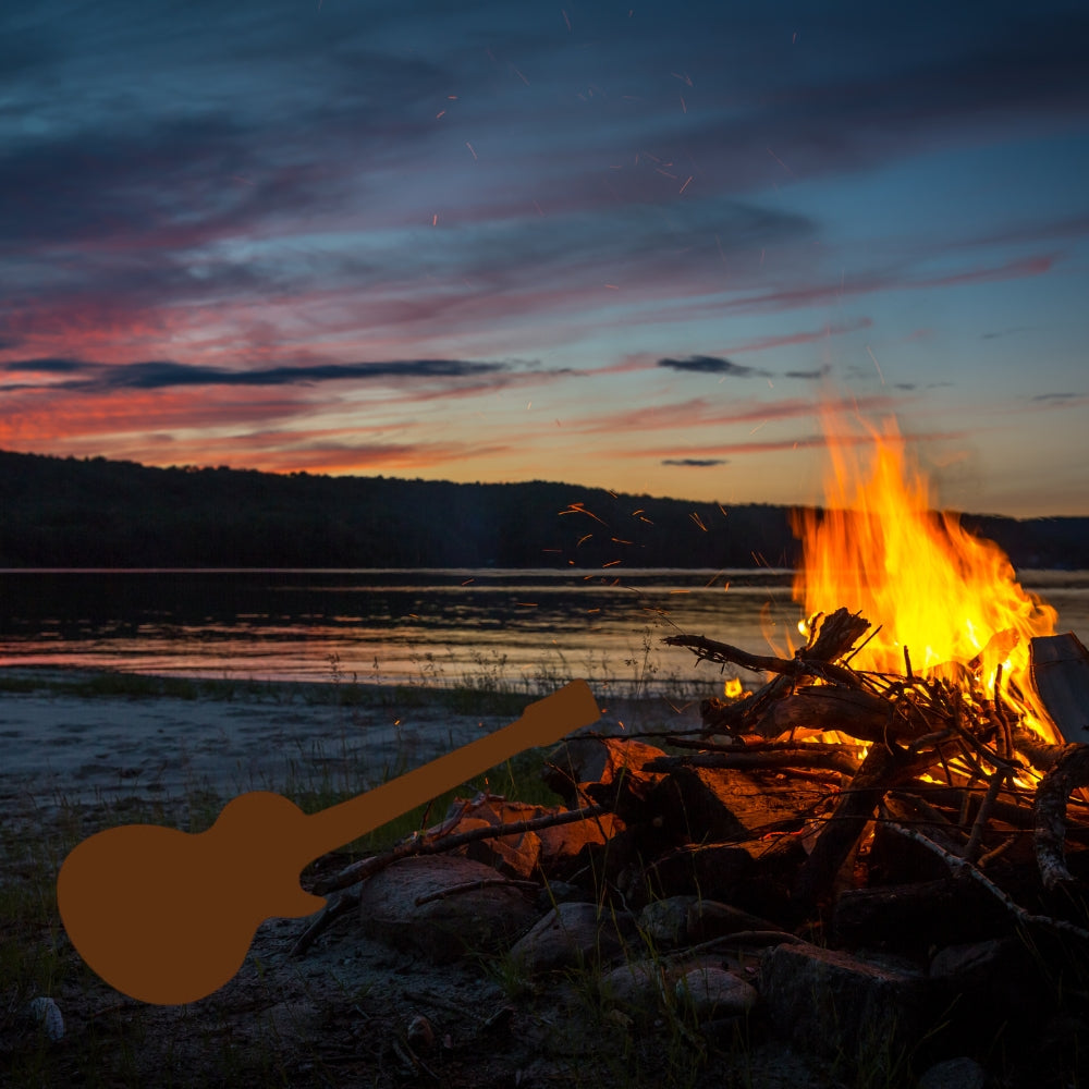 Precut glass shape of guitar by beach bonfire.