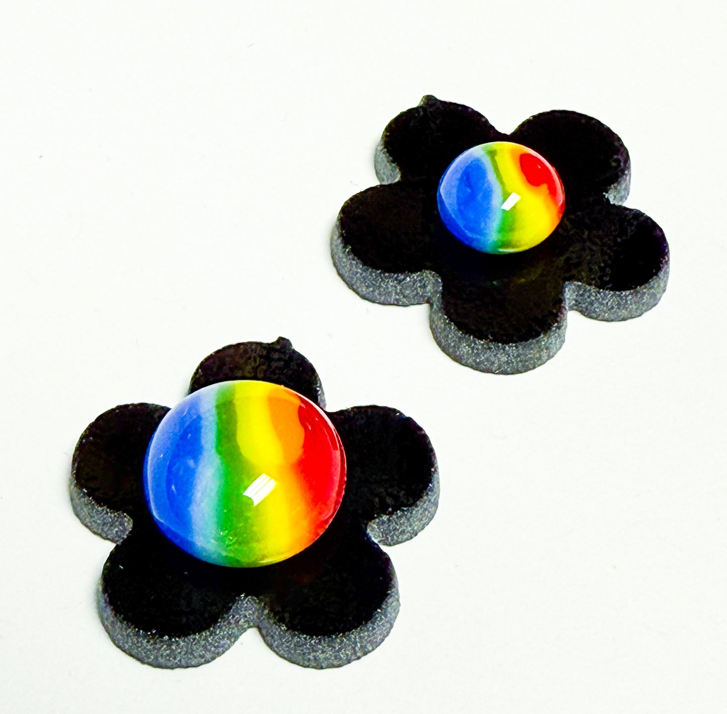 Rainbow fused glass dots used as decorative flower centers in a black floral glass base.