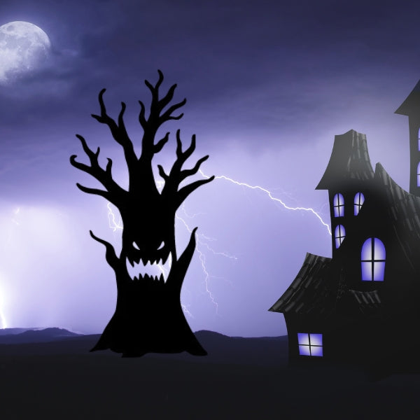 A spooky Oceanside COE 96 Halloween glass precut tree with jagged branches and a snarling face silhouette stands against a stormy night sky. Lightning cracks behind a crooked haunted house glowing purple beneath a full moon.