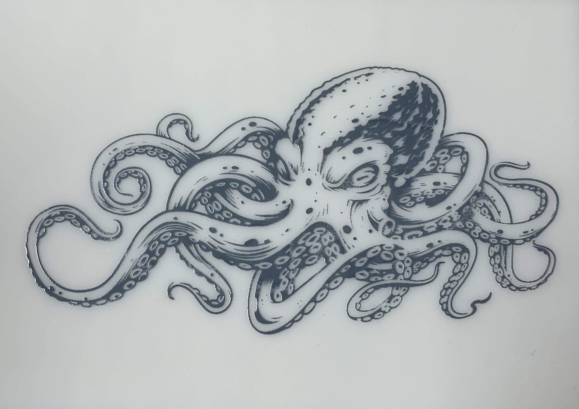 Gray octopus design screen printed on white glass, featuring expressive tentacle movement and layered detail after kiln firing